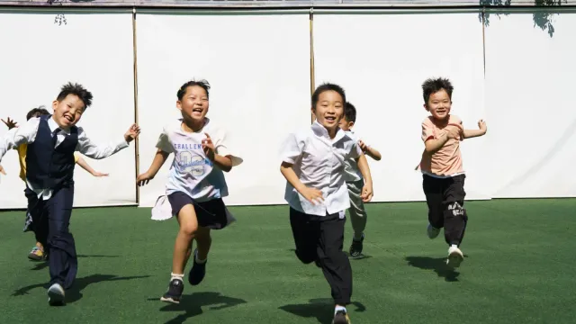 Children running together outdoors in daylight