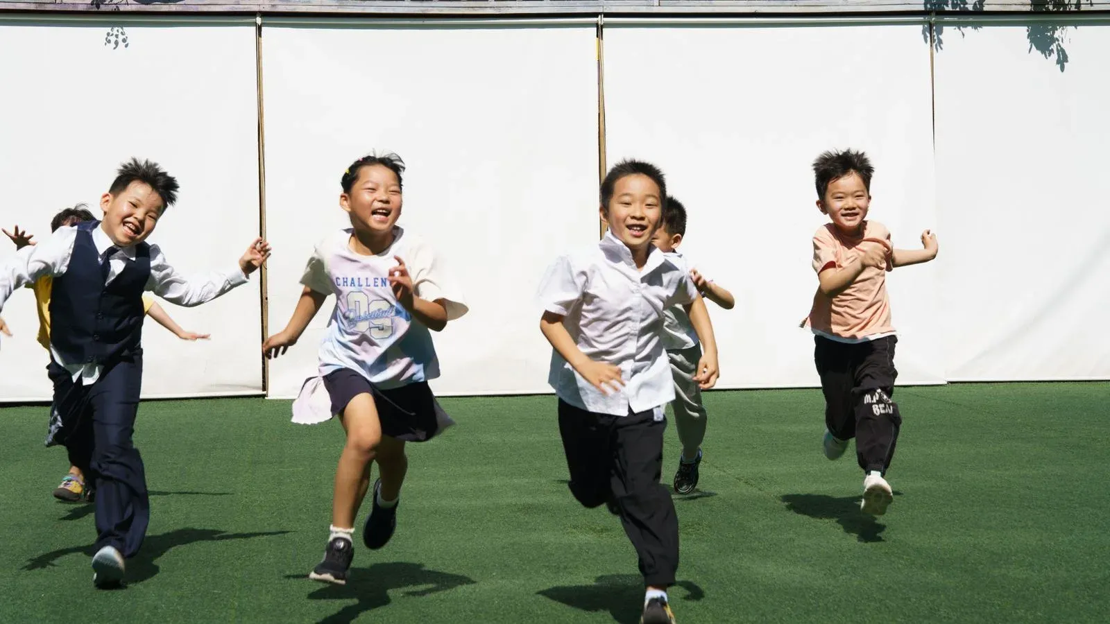 Children running together outdoors in daylight