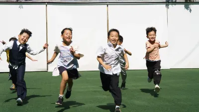 Children running together outdoors in daylight