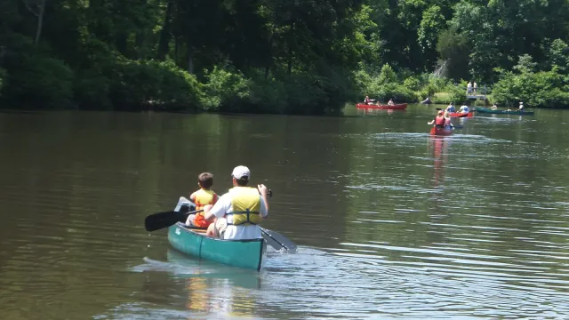 Girl Scouts canoeing on a calm lake