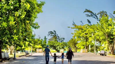 Family walking together through a sunny park plaza