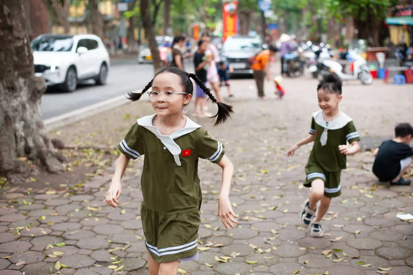 Children running together across an urban park