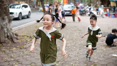 Children running together across an urban park